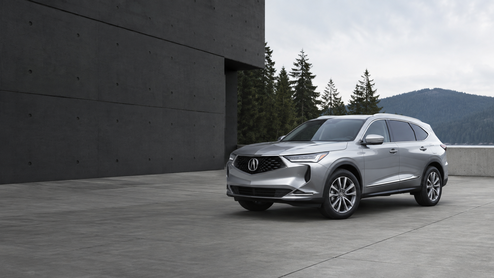 Illustrative silver Acura SUV outside modern architecture